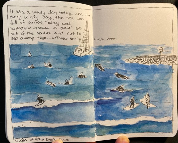 A sketch of surfers and a yacht in the sea, enclosed in a drawn frame and with a bit of text describing the scene on the top left corner.